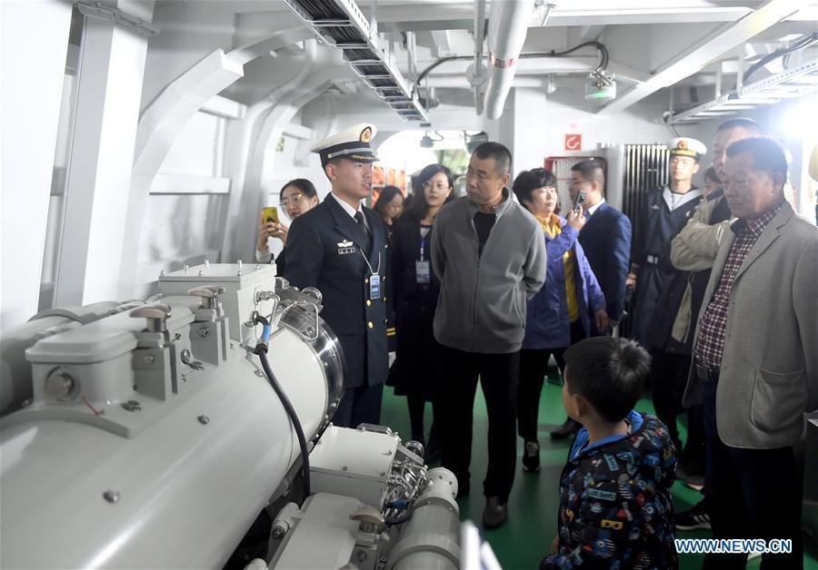 A crew member introduces torpedo installations to visitors on the guided-missile destroyer Guiyang of the Chinese People\'s Liberation Army (PLA) Navy during a warship open day event in Qingdao, east China\'s Shandong Province, April 24, 2019. A warship open day event was held on Wednesday in Qingdao, as part the multinational naval events marking the 70th founding anniversary of PLA Navy. (Xinhua/Yu Lan)