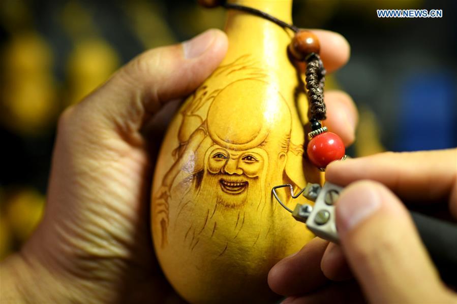 Craftsman Liu Chunpu creates cucurbit pyrography at a studio in Yuhua District of Shijiazhuang, north China\'s Hebei Province, April 23, 2019. Liu Chunpu, a staff member of Hebei Normal University, has devoted himself in cucurbit pyrography for more than 40 years. (Xinhua/Xu Jianyuan)