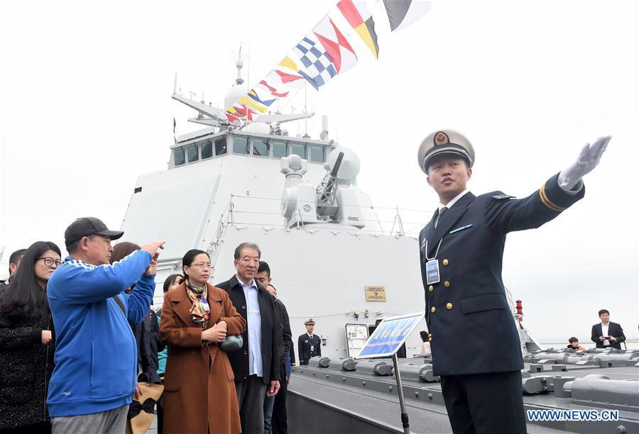 An interpreter introduces the guided-missile destroyer Guiyang of the Chinese People\'s Liberation Army (PLA) Navy to visitors during a warship open day event in Qingdao, east China\'s Shandong Province, April 24, 2019. A warship open day event was held on Wednesday in Qingdao, as part the multinational naval events marking the 70th founding anniversary of PLA Navy. (Xinhua/Luo Xiaoguang)