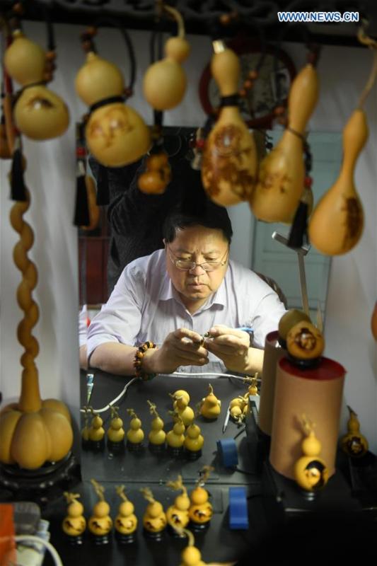 Craftsman Liu Chunpu creates cucurbit pyrography at a studio in Yuhua District of Shijiazhuang, north China\'s Hebei Province, April 23, 2019. Liu Chunpu, a staff member of Hebei Normal University, has devoted himself in cucurbit pyrography for more than 40 years. (Xinhua/Xu Jianyuan)