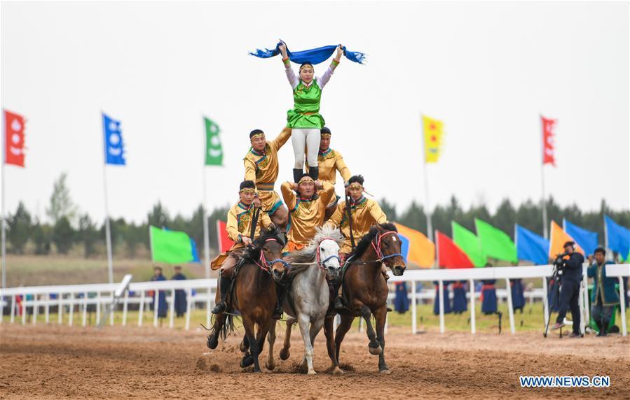 People make a human pyramid on horses at the Genghis Khan Chagan Suluk Nadam Fair in Ejin Horo Banner of Ordos City, north China\'s Inner Mongolia Autonomous Region, April 24, 2019. The two-day fair kicked off on Wednesday, including a variety of traditional activities. (Xinhua/Peng Yuan)