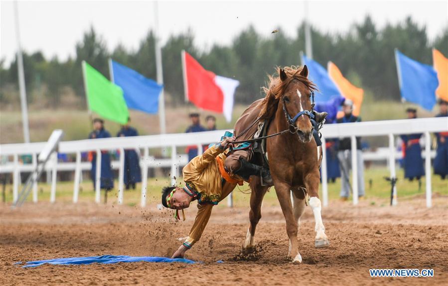 A man picks up a hada when riding a horse during the Genghis Khan Chagan Suluk Nadam Fair in Ejin Horo Banner of Ordos City, north China\'s Inner Mongolia Autonomous Region, April 24, 2019. The two-day fair kicked off on Wednesday, including a variety of traditional activities. (Xinhua/Peng Yuan)