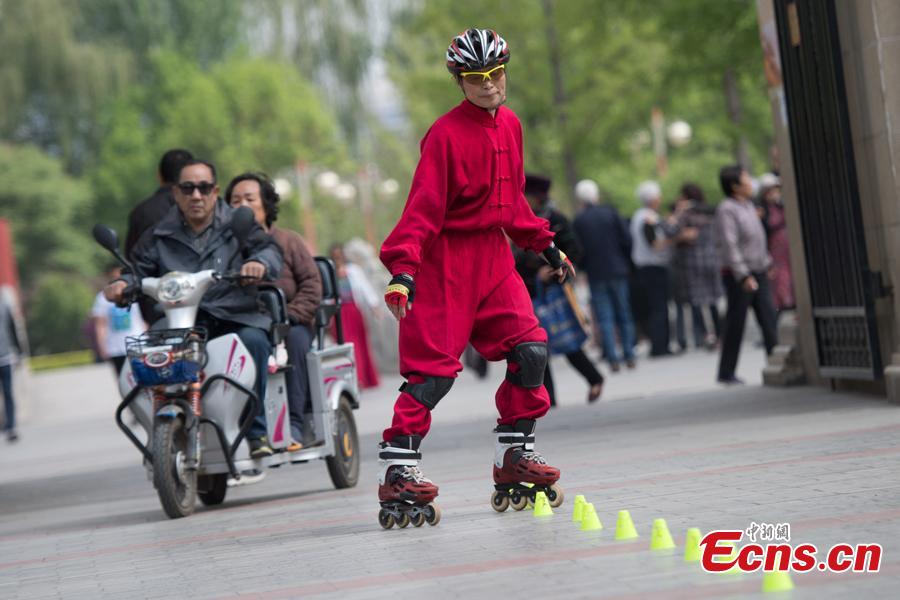 Xiao xuerong, 68, draws a crowd as she practices
roller skating in Xuefu Park in Taiyuan, Shanxi Province, April 26, 2019. (Photo/China News Service)