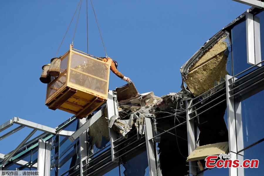 A worker suspended in a basket reaches out toward debris from a building damaged when the crane atop it collapsed a day earlier, Sunday, April 28, 2019, in Seattle. The construction crane fell from a building on Google\'s new campus during a storm that brought wind gusts, crashing down onto one of the city\'s busiest streets and killing multiple people. (Photo/Agencies)