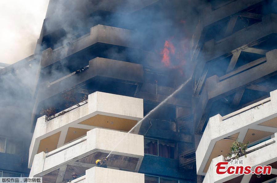 Firemen train their hose on fire in the top floors of a 21-story Pacific Coastal Plaza condominium in Manila, Philippines, April 29, 2019. Officials say more than 100 firetrucks converged Monday to battle the blaze that hit the Pacific Coast Plaza condominium in the Paranaque city area of Manila, where one lane of a coastal road along Manila Bay was closed due to falling debris. A woman died in the accident. (Photo/Agencies)
