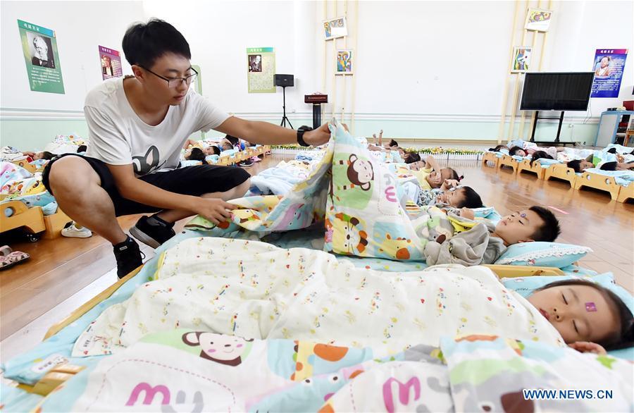 Chen Xuliang, a kindergarten teacher born in the 1990s, covers quilts for children at a kindergarten in Yangzhou, east China\'s Jiangsu Province, Sept. 4, 2018. In Chen\'s view, male teachers are rare, yet can enormously affect children\'s behaviors by different teaching methods and communication styles. Male and female kindergarten teachers are complementary in teaching and thinking. A nation will prosper only when its young people thrive; a country will be full of hope and have a great tomorrow only when its younger generations have ideals, ability, and a strong sense of responsibility. Young people always play a vanguard role in realizing national rejuvenation, which is the mission of the Chinese youth in the new era. In China many young people realize the value of life through hard work. They are writing a brilliant chapter worthy of our times in their efforts to take advantage of their youthful vigor, explore life and contribute to society. (Xinhua/Zhuang Wenbin)