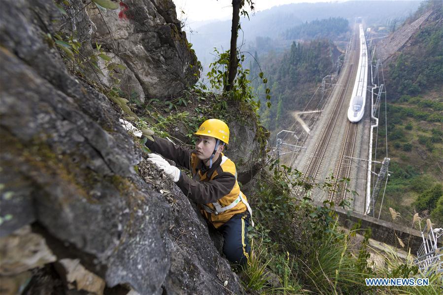 Zhang Yi, a bridge and tunnel worker born in the 1990s, is seen at an observation point while a bullet train runs on the railway in Yichang, central China\'s Hubei province, Jan. 19, 2017. Zhang checks the mountain rock day and night to ensure safety of the Yichang-Wanzhou railway line during the Spring Festival travel rush. A nation will prosper only when its young people thrive; a country will be full of hope and have a great tomorrow only when its younger generations have ideals, ability, and a strong sense of responsibility. Young people always play a vanguard role in realizing national rejuvenation, which is the mission of the Chinese youth in the new era. In China many young people realize the value of life through hard work. They are writing a brilliant chapter worthy of our times in their efforts to take advantage of their youthful vigor, explore life and contribute to society. (Xinhua/Xiong Qi)