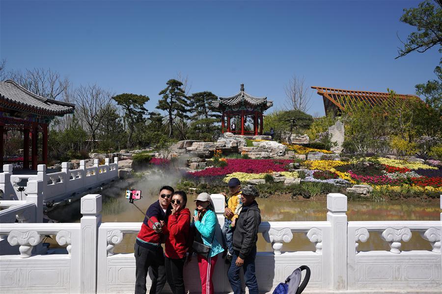 Visitors take selfies at the Beijing Garden at the International Horticultural Exhibition 2019 Beijing in Yanqing District of Beijing, capital of China, May 1, 2019. Beijing International Horticultural Exhibition welcomed its first tourist peak by serving more than 320,000 tourists during the four-day May Day holiday, the organizer said Saturday. Some 132 activities, including float parades, world ethnic and folk cultural performances, and culture and art carnivals staged by central and eastern European countries, were held during the holiday. With the theme of \