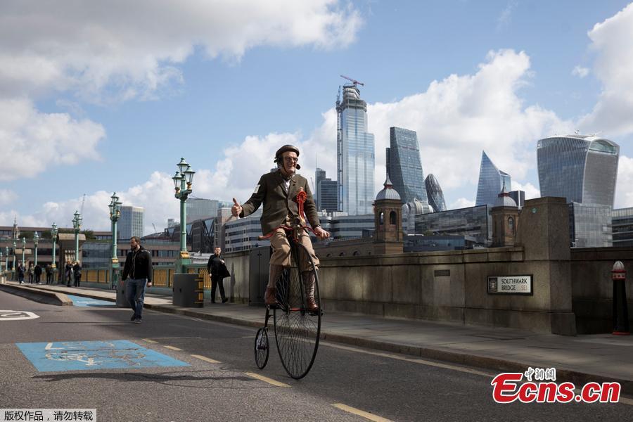 A participant rides his Penny-Farthing across Southwark Bridge as he takes part in the annual Tweed Run across London, Britain May 4, 2019. They ride through London\'s historic streets, stopping mid way for a picnic and ending with a traditional British \