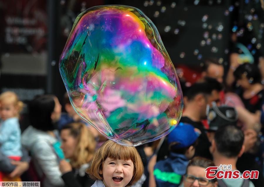 A child laughs at a soap bubble during the Global Bubble Parade in Bucharest, Romania, Sunday, May 5, 2019. Dozens took part in the Global Bubble Parade, an international event, held in 125 cities across 60 countries, according to the organizers, that brings together soap bubble fans. (Photo/Agencies)