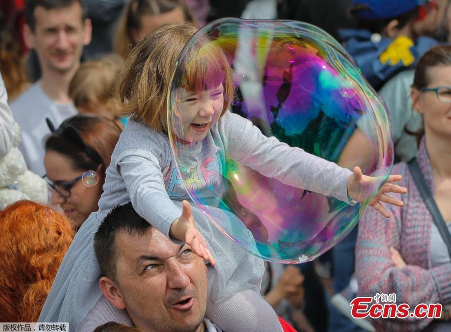 A child reaches for a soap bubble during the Global Bubble Parade in Bucharest, Romania, Sunday, May 5, 2019. Dozens took part in the Global Bubble Parade, an international event, held in 125 cities across 60 countries, according to the organizers, that brings together soap bubble fans.  (Photo/Agencies)