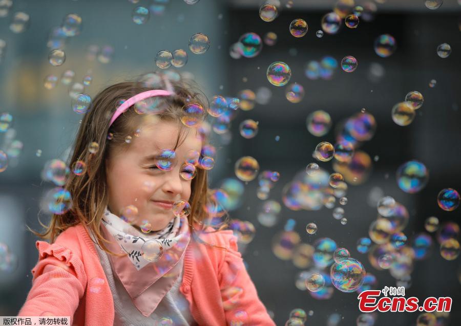Soap bubbles land on a girl\'s face during the Global Bubble Parade in Bucharest, Romania, Sunday, May 5, 2019. Dozens took part in the Global Bubble Parade, an international event, held in 125 cities across 60 countries, according to the organizers, that brings together soap bubble fans. (Photo/Agencies)