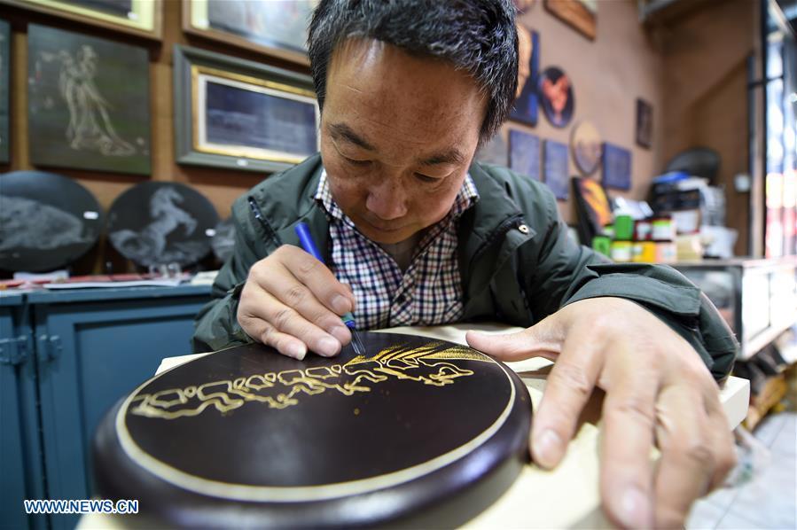 Shen Hongjie makes a woodcut at his workshop in Dunhuang, northwest China\'s Gansu Province, May 6, 2019. In 2004, Shen Hongjie was impressed by Dunhuang culture as he came here for sightseeing. He then left his hometown in central China\'s Hunan Province for Dunhuang. For 15 years, Shen Hongjie has been dedicated to promoting Dunhuang culture through woodcut. (Xinhua/Fan Peishen)