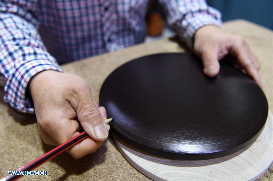 Shen Hongjie draws on wood at his workshop in Dunhuang, northwest China\'s Gansu Province, May 6, 2019. In 2004, Shen Hongjie was impressed by Dunhuang culture as he came here for sightseeing. He then left his hometown in central China\'s Hunan Province for Dunhuang. For 15 years, Shen Hongjie has been dedicated to promoting Dunhuang culture through woodcut. (Xinhua/Fan Peishen)