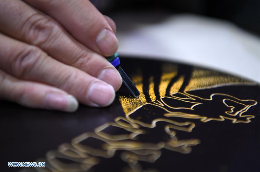 Shen Hongjie makes a woodcut at his workshop in Dunhuang, northwest China\'s Gansu Province, May 6, 2019. In 2004, Shen Hongjie was impressed by Dunhuang culture as he came here for sightseeing. He then left his hometown in central China\'s Hunan Province for Dunhuang. For 15 years, Shen Hongjie has been dedicated to promoting Dunhuang culture through woodcut. (Xinhua/Fan Peishen)
