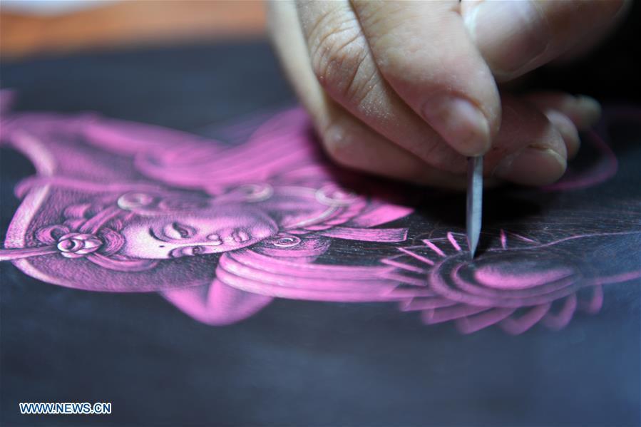 Shen Hongjie makes a woodcut at his workshop in Dunhuang, northwest China\'s Gansu Province, May 6, 2019. In 2004, Shen Hongjie was impressed by Dunhuang culture as he came here for sightseeing. He then left his hometown in central China\'s Hunan Province for Dunhuang. For 15 years, Shen Hongjie has been dedicated to promoting Dunhuang culture through woodcut. (Xinhua/Fan Peishen)