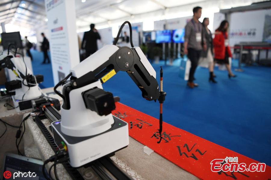 A robot performs tasks including writing calligraphy with a brush, cooking, and delivering beer after opening a bottle all on its own during the 6th China Robotop Summit in Ningbo City, East China\'s Zhejiang Province, May 9, 2019. According to its official website, the summit aims to promote the application of robots in intelligent manufacturing. (Photo/IC)