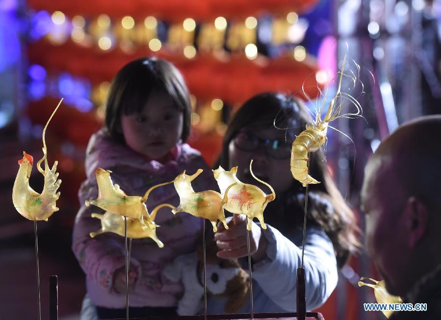 People view a performance of sugar-figure blowing by a folk artist during a lantern fair in Beijing, capital of China, Feb. 28, 2018. China will hold the Conference on Dialogue of Asian Civilizations starting from May 15. Under the theme of \