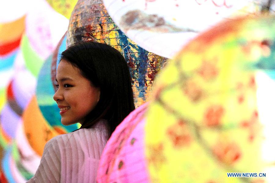 A girl poses among lantern decorations at the Chinatown in Manila, the Philippines, Feb. 2, 2019. China will hold the Conference on Dialogue of Asian Civilizations starting from May 15. Under the theme of \