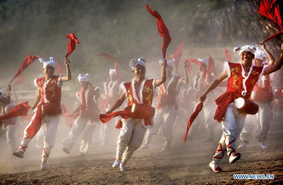 Villagers perform Ansai waist drums for tourists at Fengjiaying Village in Ansai District of Yan\'an City, northwest China\'s Shaanxi Province, May 30, 2018. China will hold the Conference on Dialogue of Asian Civilizations starting from May 15. Under the theme of \
