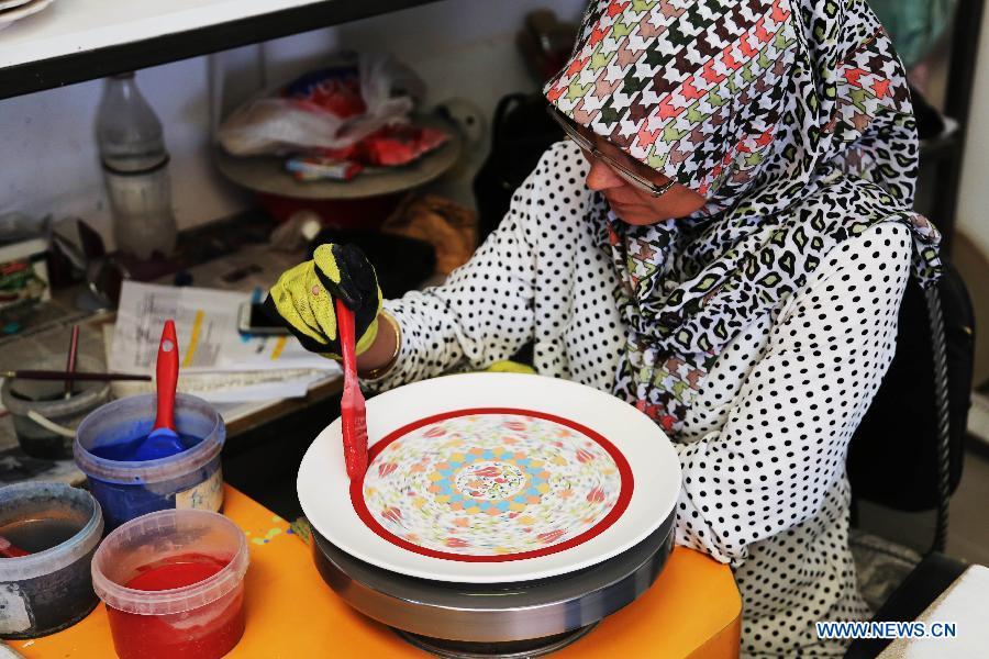 An artist paints on a Cini base at a factory in Kutahay, Turkey, April 25, 2017. Cini is a kind of traditional faience pottery making industry originated in China. China will hold the Conference on Dialogue of Asian Civilizations starting from May 15. Under the theme of \