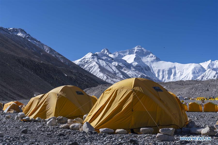 Tents of expedition teams are seen at the base camp of the northern face of Mount Qomolangma in southwest China\'s Tibet Autonomous Region, April 25, 2019. Every year, for a few weeks, hundreds of climbers and supporting personnel come to the base camp of the northern face of Mount Qomolangma, trying to reach the summit of the tallest and most famous mountain in the world. Before starting climbing, they need to hike several times between elevations from 5,000 meters to 7,000 meters, giving their bodies some time to adapt. When this process is over, it\'s all up to the weather. The base camp is a popular place to wait for the window. Among the six camps on the northern face, the base camp at an altitude of 5,200 meters is the furthest cars can reach and therefor the most equipped. Besides food and accommodation, climbers can also enjoy tea and massage. They can also play football on perhaps the highest field. There\'s even a simple gym in the camp. Environmental protection is a priority here. Garbage sacks are given to each climbing team. Special containers are put in every camp to collect trash and sewage. The collected trash must be treated 100 kilometers away, and the only road is a zigzagging track. It is not trucks, but yaks that are generally used to make the journey. Actually yaks are vital on the mountain. Beyond the base camp, yak is the only reliable transport. (Xinhua/Sun Fei)
