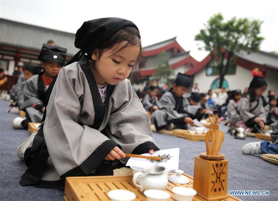 Children experience tea art in Jia Pingwa Pavillion in Xi\'an, northwest China\'s Shaanxi Province, on April 21, 2019. As an important part of Asian culture, tea is a special bond among Asian countries to deepen friendship and boost mutual exchanges. China will hold the Conference on Dialogue of Asian Civilizations starting from May 15. Under the theme of \