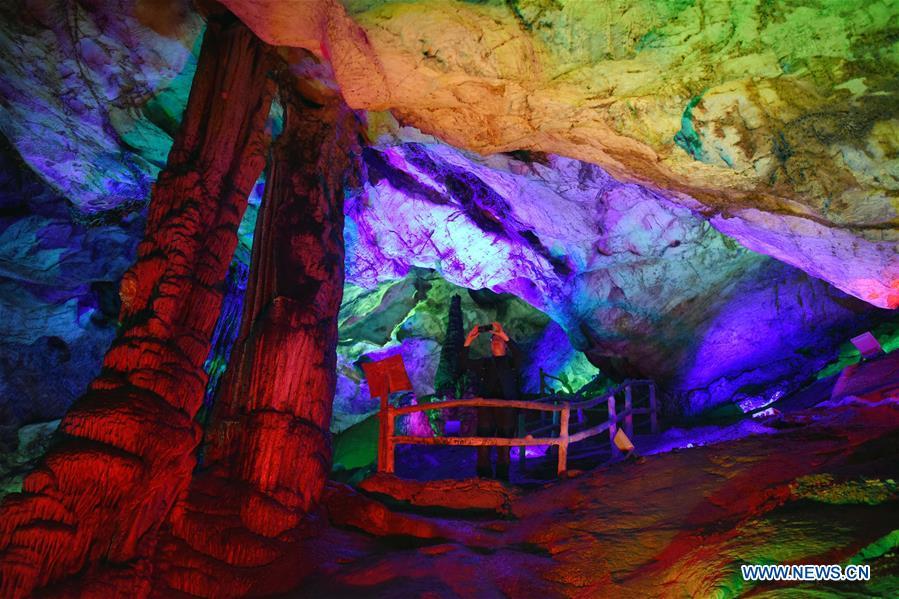 A tourist takes pictures in Wanxiang karst cave in Hanwang Township of Longnan City, northwest China\'s Gansu Province, May 13, 2019. (Xinhua/Ma Ning)