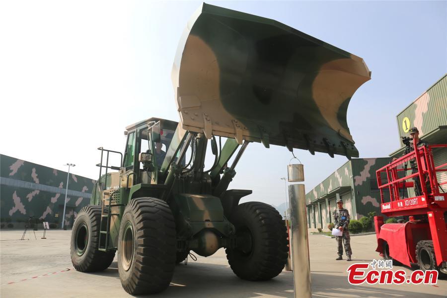 A unit of the People\'s Liberation Army Rocket Force held a skills contest where 100 military engineers competed to maneuver vehicles and machines including excavators, loaders, cranes, and forklifts passed various obstacles. (Photo: China News Service/Fang Lei)