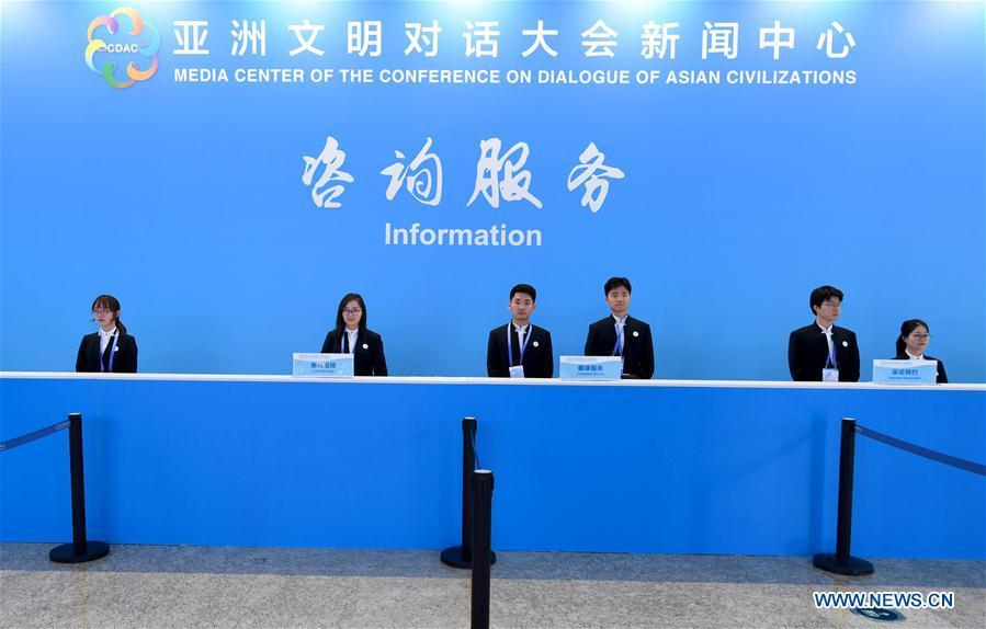 Volunteers work at the information desk of the media center of the Conference on Dialogue of Asian Civilizations in the China National Convention Center in Beijing, capital of China, May 14, 2019. The Conference on Dialogue of Asian Civilizations will open on Wednesday. (Xinhua/Wang Yuguo)