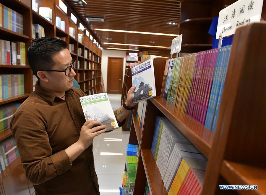 Sangay Tenzin reads books at a book store of the Beijing Language and Culture University in Beijing, capital of China, May 14, 2019. Sangay Tenzin, a Bhutanese student of Beijing Language and Culture University, is one of the photographers whose work was accepted by an exhibition themed \