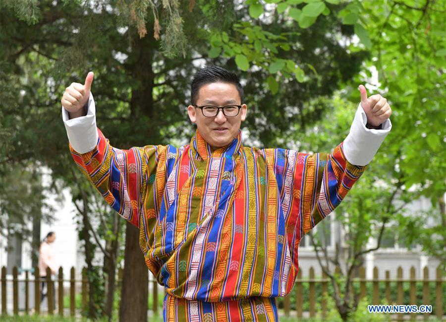 Sangay Tenzin displays traditional costumes made by his mother on the campus of the Beijing Language and Culture University in Beijing, capital of China, May 14, 2019. Sangay Tenzin, a Bhutanese student of Beijing Language and Culture University, is one of the photographers whose work was accepted by an exhibition themed \