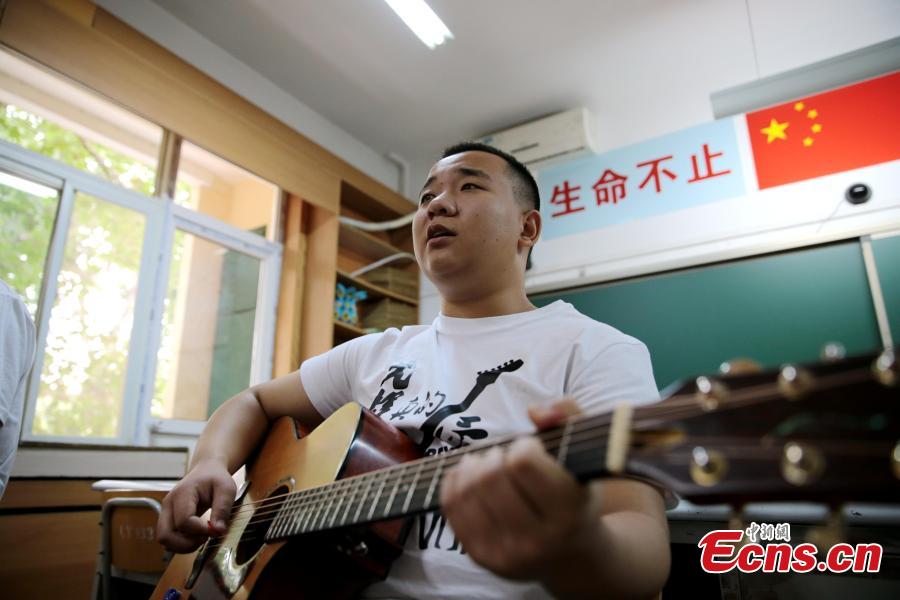 Gao Yu, the lead singer of a band composed of four visually-impaired students, sings during a rehearsal at a school in Xi’an City, Northwest China’s Shaanxi Province, May 14, 2019. The four students, all born after the year 2000, call their band Zhong Mu Tou, which literally means “heavy log’, and they mainly perform ballads and rock songs. (Photo: China News Service/Zhang Yuan)