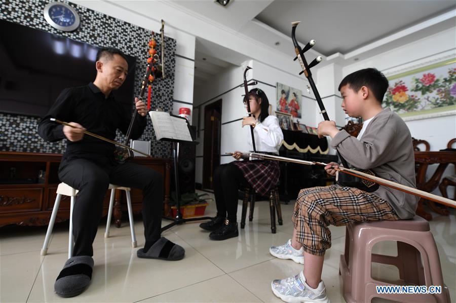 Erhu performer Zhang Zhijun (1st L) instructs his students in Lanzhou, northwest China\'s Gansu Province, May 13, 2019. Erhu, sometimes known as the Chinese violin or Chinese two-stringed fiddle, is a Chinese traditional two-stringed bowed musical instrument. It is used as a solo instrument as well as in small ensembles and large orchestras. Erhu, traced back to ancient Chinese Tang dynasty (618-907), is now used in both traditional and contemporary music arrangements, such as in pop, rock and jazz. The famous solo pieces include Er Quan Ying Yue (Two Springs Reflecting the Moon) by Abing and Sai Ma (Horse Race) by Huang Haihuai. (Xinhua/Fan Peishen)