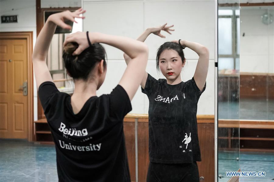 Feng Ganyu fixes her hair before dancing in a training room at Beijing Normal University in Beijing, capital of China, May 12, 2019. A photographic exhibition themed \