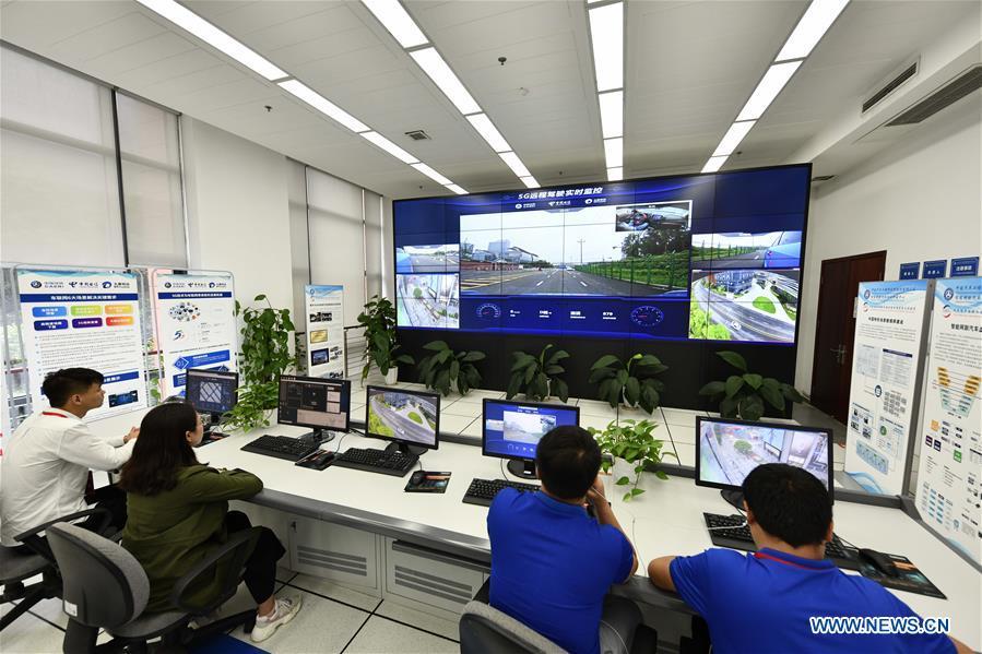 Researchers watch the data and image feedback during a test run for a remote-controlled car in Chongqing, southwest China, May 15, 2019. A remote-controlled car powered by the 5G network completed a test run on Wednesday in Chongqing. During the test run, a remote operator was able to control the car while watching the live feed of road conditions supported by the 5G network. (Xinhua/Liu Chan)