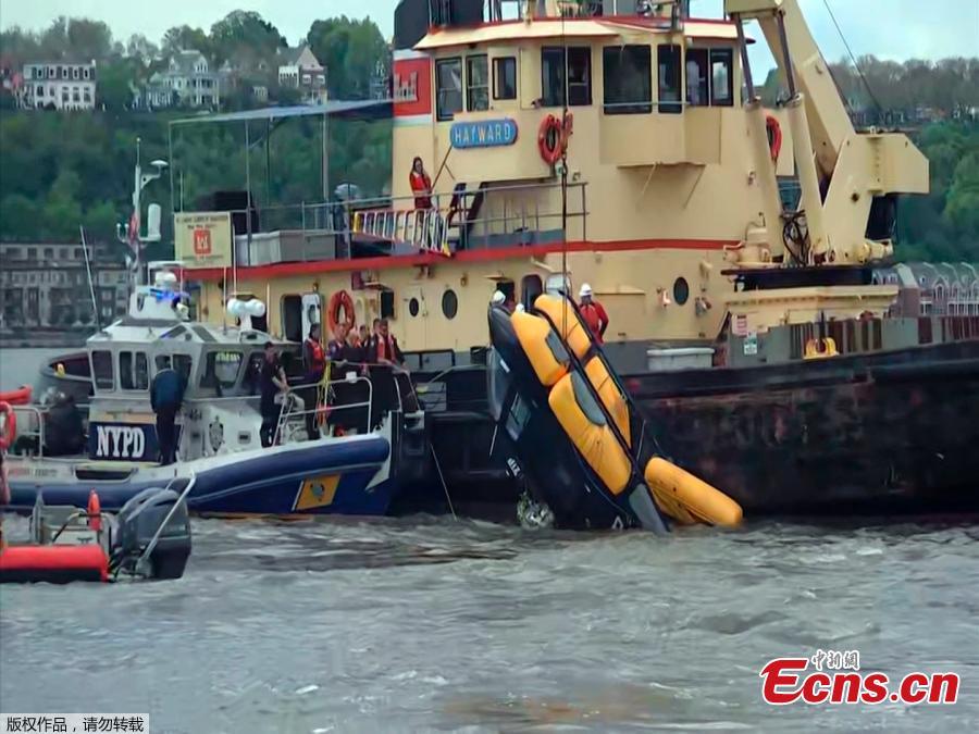 A helicopter is loaded, by crane, onto a barge after it crashed into the Hudson River on May 15, 2019 in New York.  A helicopter crashed into the Hudson River on May 15 afternoon shortly after taking off from a Manhattan heliport, authorities said. The pilot, identified as Eric Morales, was rescued by a passing NY Waterway ferry a short time later. (Photo/Agencies)