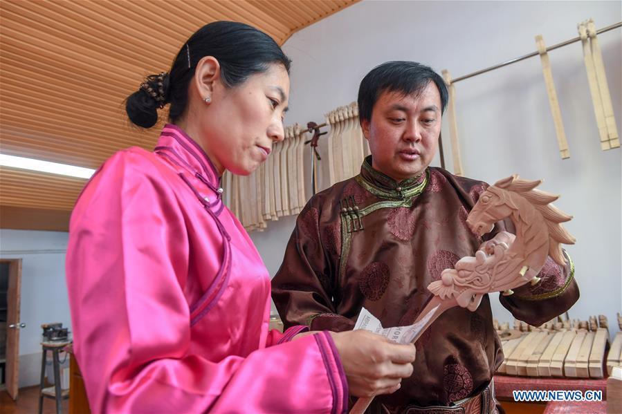 Baisu Gulang, a 37-year-old horse head fiddle maker, teaches his apprentice Zhang Hongxue to make a horse head fiddle in Qian Golos Mongolian Autonomous County of Songyuan, northeast China\'s Jilin Province, May 15, 2019. Under his father\'s influence, Baisu Gulang has an ardent love in making and playing horse head fiddle, a traditional musical instrument favored by Mongolian ethnic group. He started learning to make horse head fiddle when he was 18 years old. In 2006, Baisu Gulang started a horse head fiddle making studio where he voluntarily teaches enthusiasts to make and play the instrument besides selling. (Xinhua/Zhang Nan)