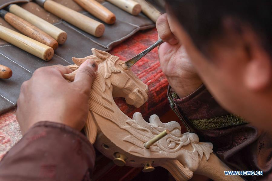 Baisu Gulang, a 37-year-old horse head fiddle maker, makes a horse head fiddle in Qian Golos Mongolian Autonomous County of Songyuan, northeast China\'s Jilin Province, May 15, 2019. Under his father\'s influence, Baisu Gulang has an ardent love in making and playing horse head fiddle, a traditional musical instrument favored by Mongolian ethnic group. He started learning to make horse head fiddle when he was 18 years old. In 2006, Baisu Gulang started a horse head fiddle making studio where he voluntarily teaches enthusiasts to make and play the instrument besides selling. (Xinhua/Zhang Nan)