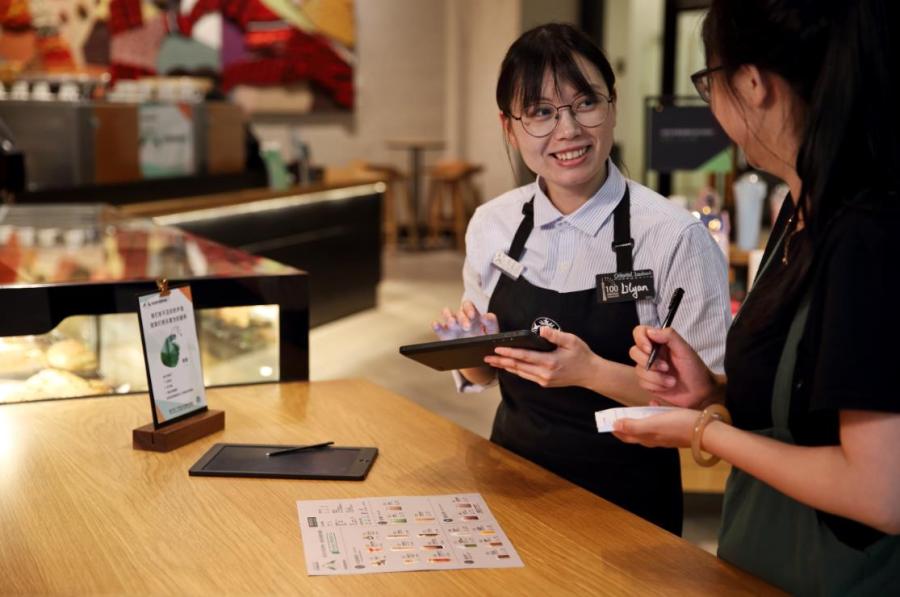 An employee able to communicate in sign language works at Starbucks China\'s first store with sign language capability in Guangzhou\'s Yuexiu district, May 19, 2019. (Photo provided to chinadaily.com.cn)
For customers new to sign language, there will be a dedicated area for customers to write down their orders on an electronic board and wireless vibrating pagers will notify customers when their orders are ready.

To create an inclusive environment and encourage customers to learn more about the deaf community, the store also will offer sign language lessons and coffee workshops in sign language, in partnership with the Guangdong Deaf People Association.

This is Starbucks\' third signing store worldwide, after Kuala Lumpur and Washington.