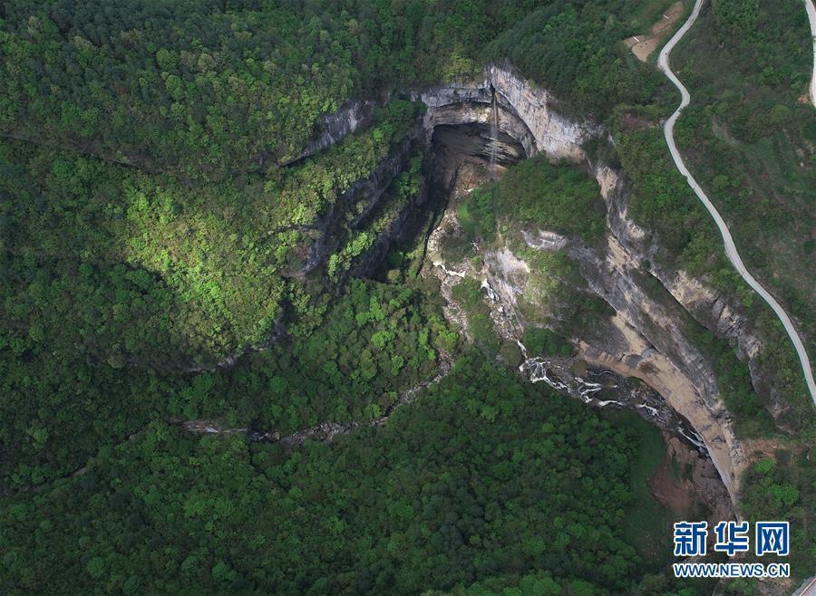 An aerial photo shows a waterfall in Didonghe Tiankeng, a giant karst sinkhole at Huoshizi Village of Ningqiang County in Hanzhong, northwest China\'s Shaanxi Province. With a maximum depth of 340 meters, the Didonghe Tiankeng is the largest in Chanjiayan Tiankeng Group in Ningqiang County. (Photo/Xinhua)