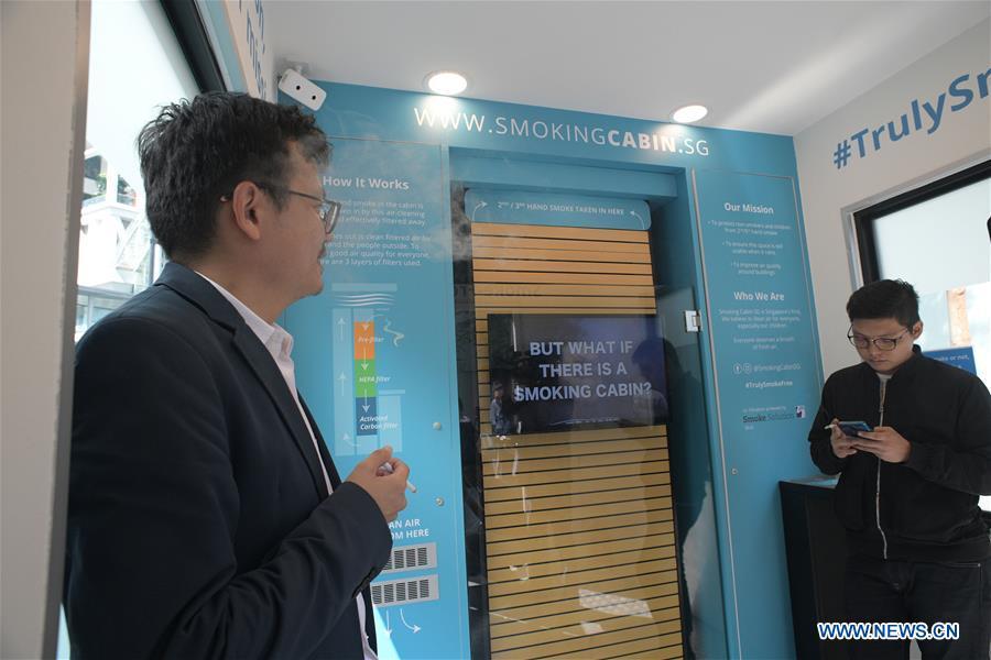 Men smoke inside a smoking cabin in Singapore on May 21, 2019. Singapore\'s first smoking cabin was launched on Tuesday. The air-conditioned cabin measures 4.8 square metres in size, that allows a maximum of 10 users at one time, and uses 3 filters to filter the air inside. (Xinhua/Then Chih Wey)