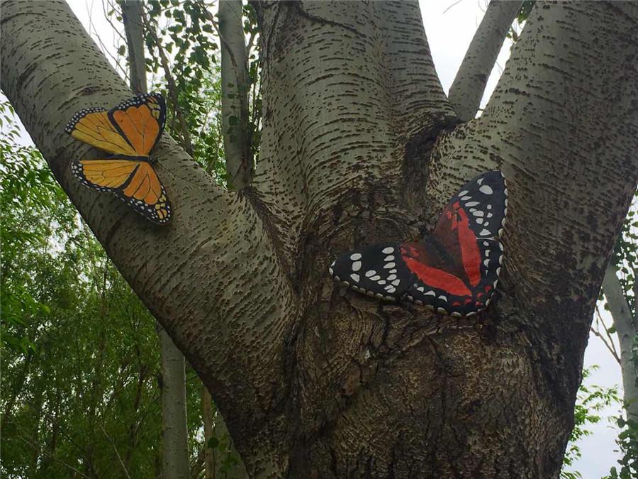 A tree trunk is painted with butterflies in the Zoological and Botanical Garden in Changchun, capital of Northeast China\'s Jilin Province.  (Photo/chinadaily.com.cn)