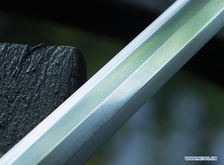 Photo taken on May 21, 2019 shows a sword being made in Longquan, east China\'s Zhejiang Province. For centuries, Longquan has been famed for its sword making industry. Zheng Guorong, 55, an intangible cultural heritage inheritor in Longquan Sword making, has been making sword for more than 30 years. Zheng regards sword as a symbol of spirit and devotes all to his career with awe. In his studio, the whole process of making a single sword takes two to three months, with steps including forming an idea, designing the sketch, preparing material and the final making and assembling. After setting up his studio, Zheng has trained more than 20 apprentices, who have all become sword smiths of great reputation. The old sword smith insists that Longquan sword, with a history of more than 2,500 years, deserves to be carried on in our time, both materially and spiritually. (Xinhua/Weng Xinyang)