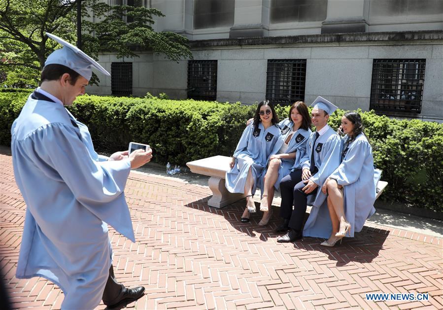 Graduate students pose for photos on campus after the Columbia University Commencement ceremony in New York, the United States, May 22, 2019. The Columbia University Commencement ceremony of the 265th academic year took place on Wednesday. More than 17,000 students from Columbia\'s 18 schools and affiliates graduated this year. (Xinhua/Wang Ying)