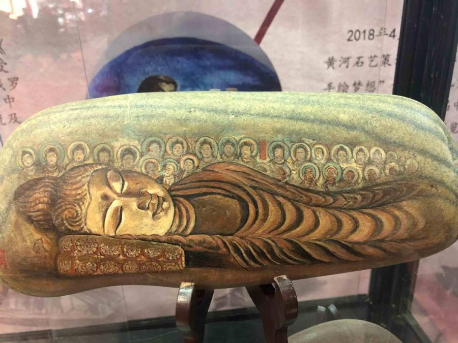 Chen Juzheng, 58, from Lanzhou, capital of Gansu Province, collects stones from the Yellow River banks and paints them with historical paintings and frescoes found in the Mogao Grottoes of Dunhuang.   (Photos by Xu Xue/for chinadaily.com.cn)