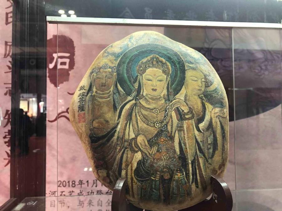 Chen Juzheng, 58, from Lanzhou, capital of Gansu Province, collects stones from the Yellow River banks and paints them with historical paintings and frescoes found in the Mogao Grottoes of Dunhuang.  (Photos by Xu Xue/for chinadaily.com.cn)