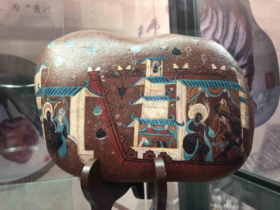 Chen Juzheng, 58, from Lanzhou, capital of Gansu Province, collects stones from the Yellow River banks and paints them with historical paintings and frescoes found in the Mogao Grottoes of Dunhuang.  (Photos by Xu Xue/for chinadaily.com.cn)