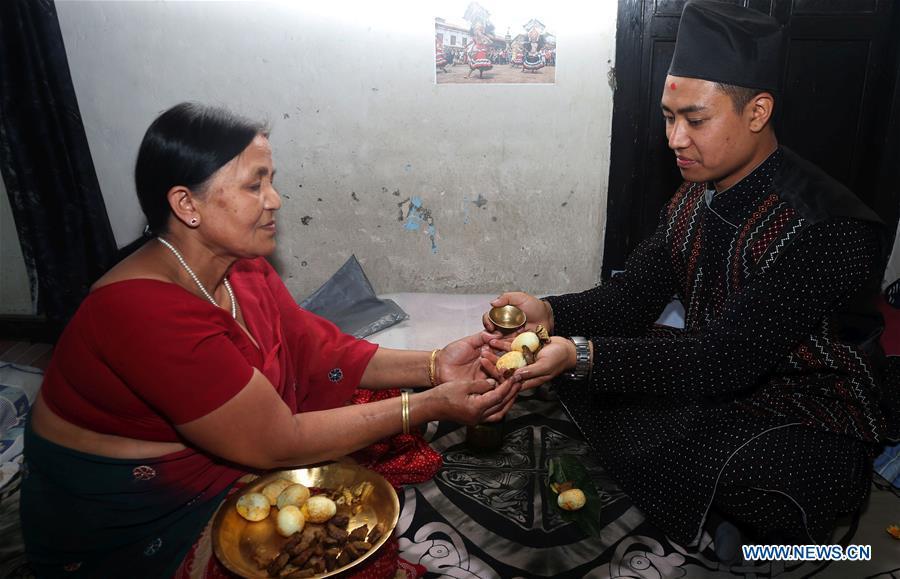 Binaya Hada (R) receives blessings from his mother at home in Bhaktapur, Nepal on May 15, 2019. Binaya Hada is a 34-year-old Nepali young man, whose work was selected for a photographic exhibition on Asian civilization. Graduated from Beijing Language and Culture University of China, Binaya is now dedicated to learning Chinese culture and popularizing knowledge of Chinese language to local population. (Xinhua/Sunil Sharma)