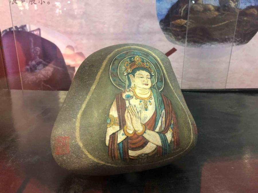 Chen Juzheng, 58, from Lanzhou, capital of Gansu Province, collects stones from the Yellow River banks and paints them with historical paintings and frescoes found in the Mogao Grottoes of Dunhuang.  (Photos by Xu Xue/for chinadaily.com.cn)